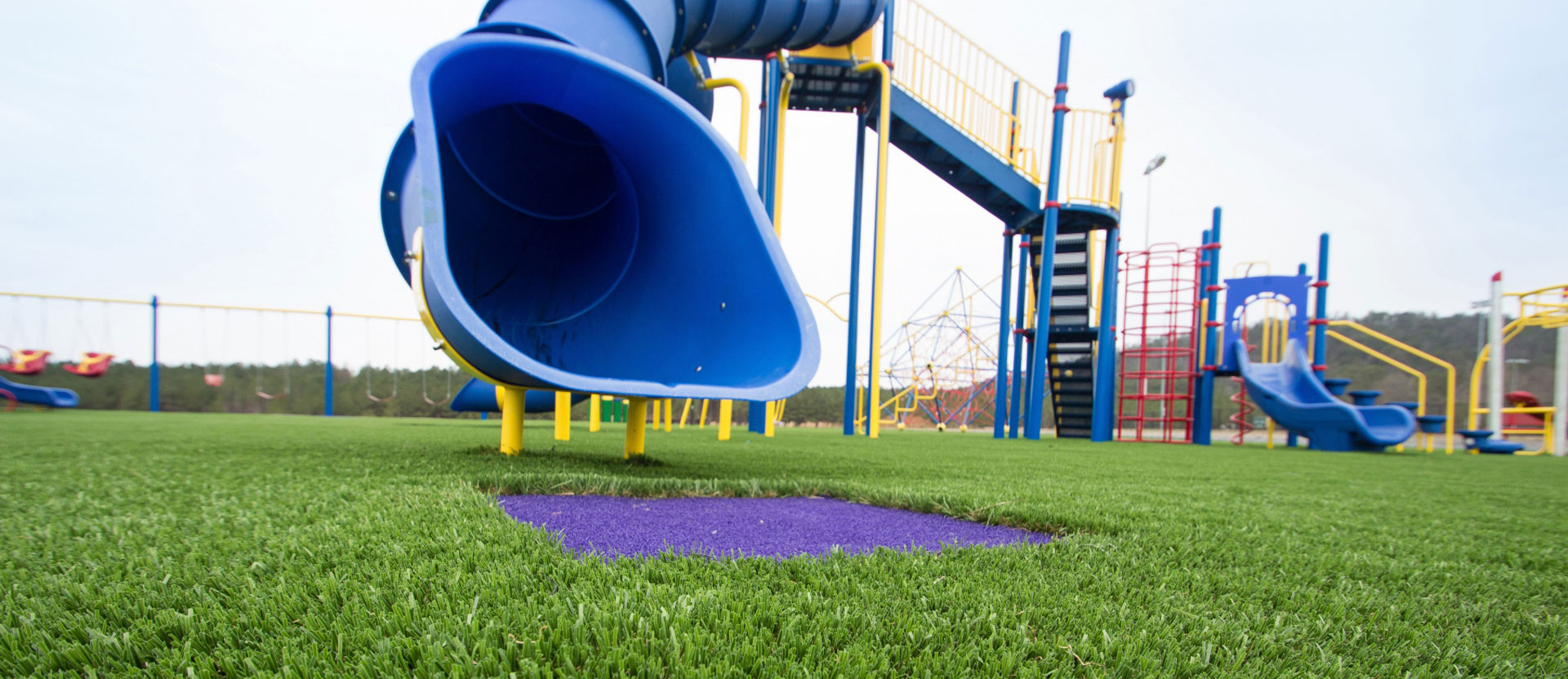 Artificial playground grass with blue slide